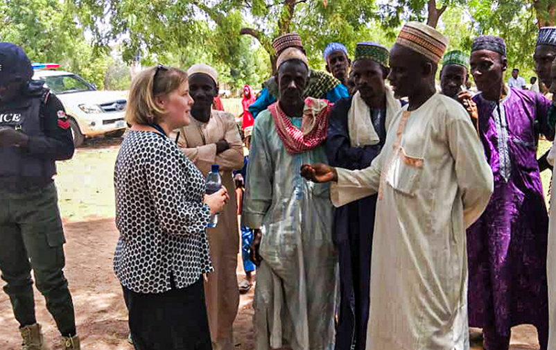 Valobservatören Rebecca Palmer samtalar med en grupp män i Nigeria.