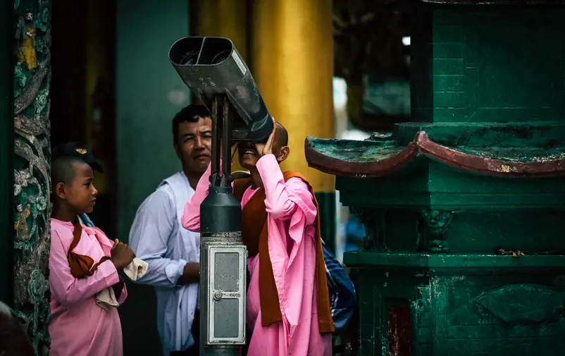 Buddhist monks looking at the heaven through binoculars.