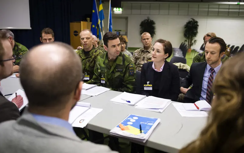 Civil och militär personal har möte tillsammans.