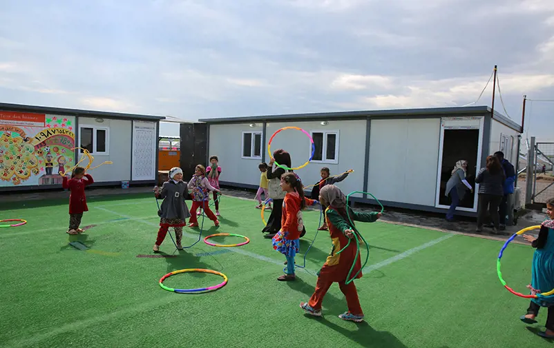 Girls playing with hula-hoops and skipping ropes.